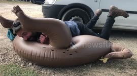 Man tries to deflate inflatable sloth
