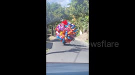 'Real-life Up?' Balloon man on motorbike struggles not to get blown away by wind