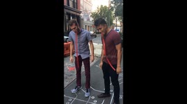 Two men race to eat entire fruit by the foot with using their hands