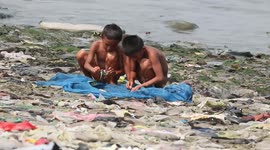 Children play amongst plastic waste piling up on beach in Indonesia