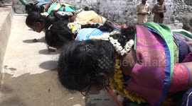 Indian women eat from the floor with hands behind back in bizarre fertility ritual