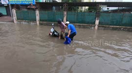 Two men failed to drive a motorbike through a flooded street in Vietnam