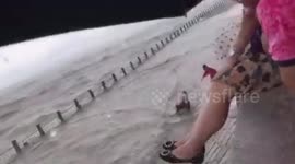 Chinese man escapes being swept out to sea after large wave knocks him off his feet