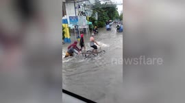 Pedestrians wade through flood water in the Philippines