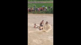 The men tried to rescue the car washed away by the flood