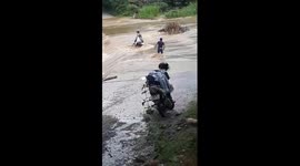 The man was lucky to escape death when he tried to cross the flooded road