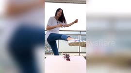 Chinese woman uses roundhouse kick to light match held by crayfish