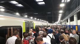 Long line of passengers wait to board train at Euston station in London