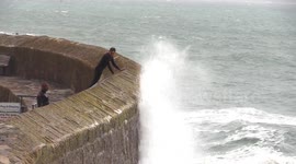 Huge waves crash over harbour wall in Cornwall drenching locals braving the rough seas