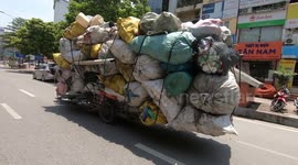 Serious overloaded tricycles in Vietnam carry more than 30 large sacks of goods