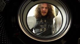 Man loads washing machine with dirty dishes