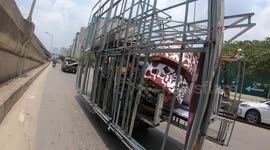 Tricycle carries huge iron frames through the streets of Vietnam