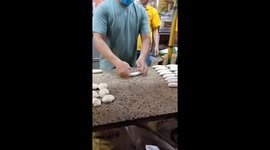 Two men show off the skill of making wheat flour cake very quickly on the street