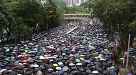 Protesters in Hong Kong begin marching through the streets of Hong Kong Island in the rain