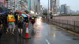 Protesters march through rain soaked streets, allowing traffic to flow in one lane