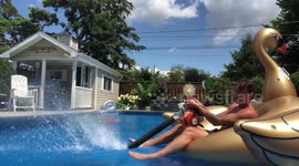 Man has lazy fun by using the help of a leaf blower to float around the pool