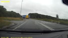 Truck's trailer drifts in wet weather and approaches oncoming traffic on UK road
