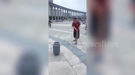 Elderly Chinese man spins 15 kg gas canister using a drill
