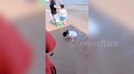 Chinese girl refuses to give up as the sea keeps on washing away her heart drawing