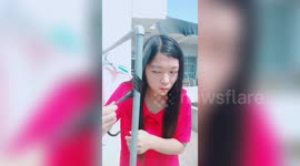 Chinese girl uses a hot outdoor water pipe to curl her hair