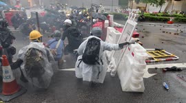 Hong Kong Anti Extradition Bill Protests in Tsuen Wan, protesters taking cover behind barricades as police fire tear gas