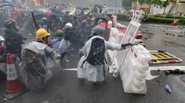 Hong Kong protesters take cover behind barricades as police fire tear gas