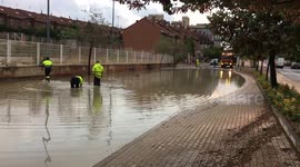 Road maintenance workers attempt to drain road after storm batters Madrid