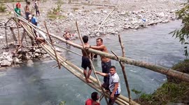 Villagers waiting six years for bridge to be finished make their own from bamboo