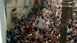 Residents in Spain battle to climb a pole during the infamous La Tomatina festival