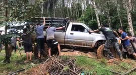 Friends help to free pickup truck stranded on muddy hill
