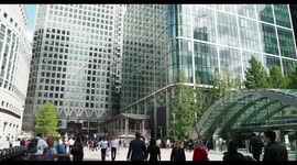 crowds walking in canary wharf, london docklands, with the famous clocks