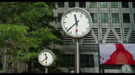 crowds walking in canary wharf, london docklands, with the famous clocks