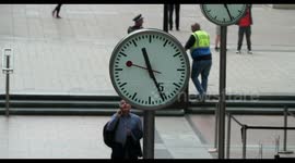 crowds walking in canary wharf, london docklands, with the famous clocks