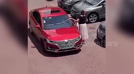 Chinese woman uses tape measure to make sure car fits in parking space