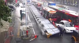 Motorists lift up fence after it was blown over onto several pedestrians in China