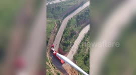 Truck transports 70-metre-long wind turbine blade on winding road in China
