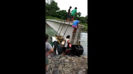 Schoolchildren in the Philippines avoid metal spikes as they cross river on unfinished bridge