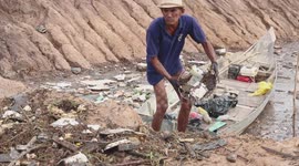 Cambodian grandfather hailed a hero for using his boat to collect piles of rubbish in a lake