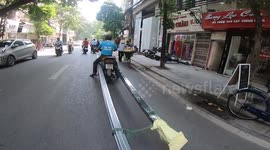 Man transports huge metal rods through Vietnam streets on motorbike