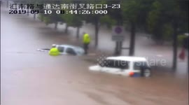 Chinese police officer kicks in truck windscreen to rescue driver trapped in floodwater