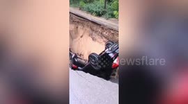 Huge sinkhole swallows two cars after opening up on Chinese road