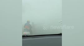 Drivers battle through thick haze caused by forest fires in Indonesia