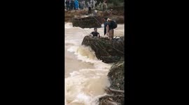 Man risks his life by wading through rapid floodwater in Vietnam