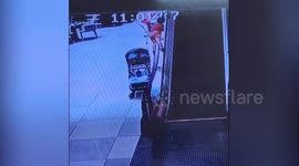 Toddler scales escalator in Chinese mall by hanging onto handrail