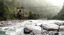 Man gets wheeled along trolley ropeway over river in north India