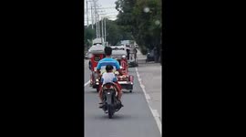 Filipino child rides pillion on motorcycle