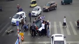 Motorists and passersby lift up car after woman is trapped underneath it on Chinese road