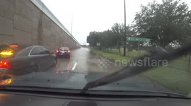 Driving through floodwaters past stalled vehicles during Tropical Storm Imelda