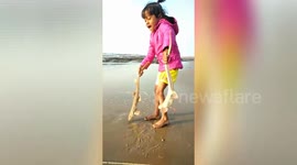 Adorable little girl rescues two small sharks in India