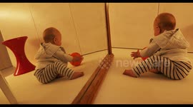 adorable baby kisses herself in a mirror